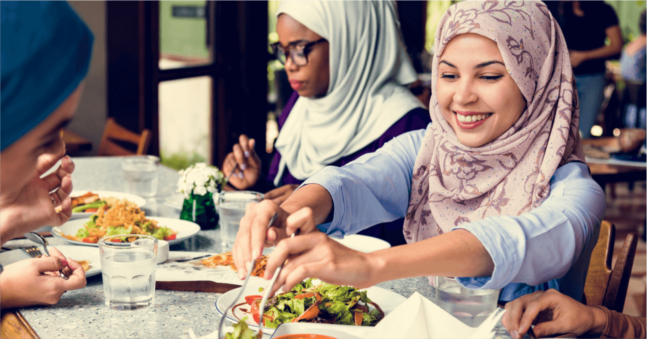 A group of women sitting around a table eating food.
