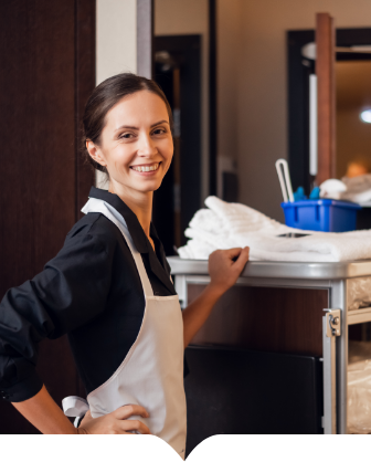 A woman in an apron standing in front of a counter.
