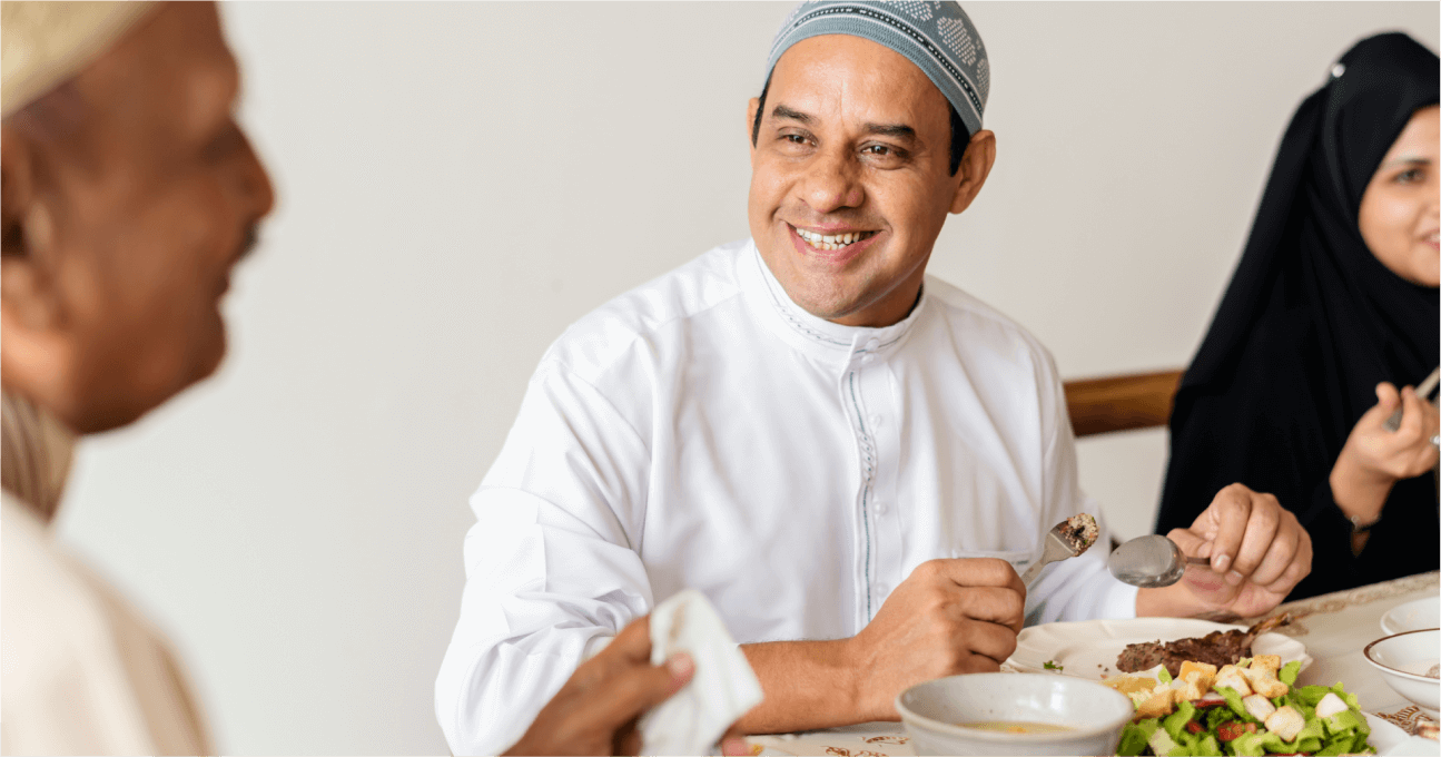 A man sitting at a table with a plate of food.