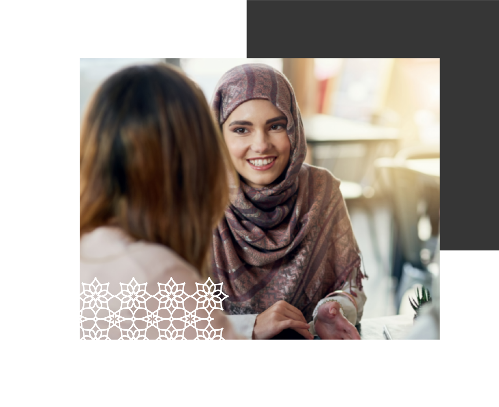 A woman in a headscarf talking to another woman.